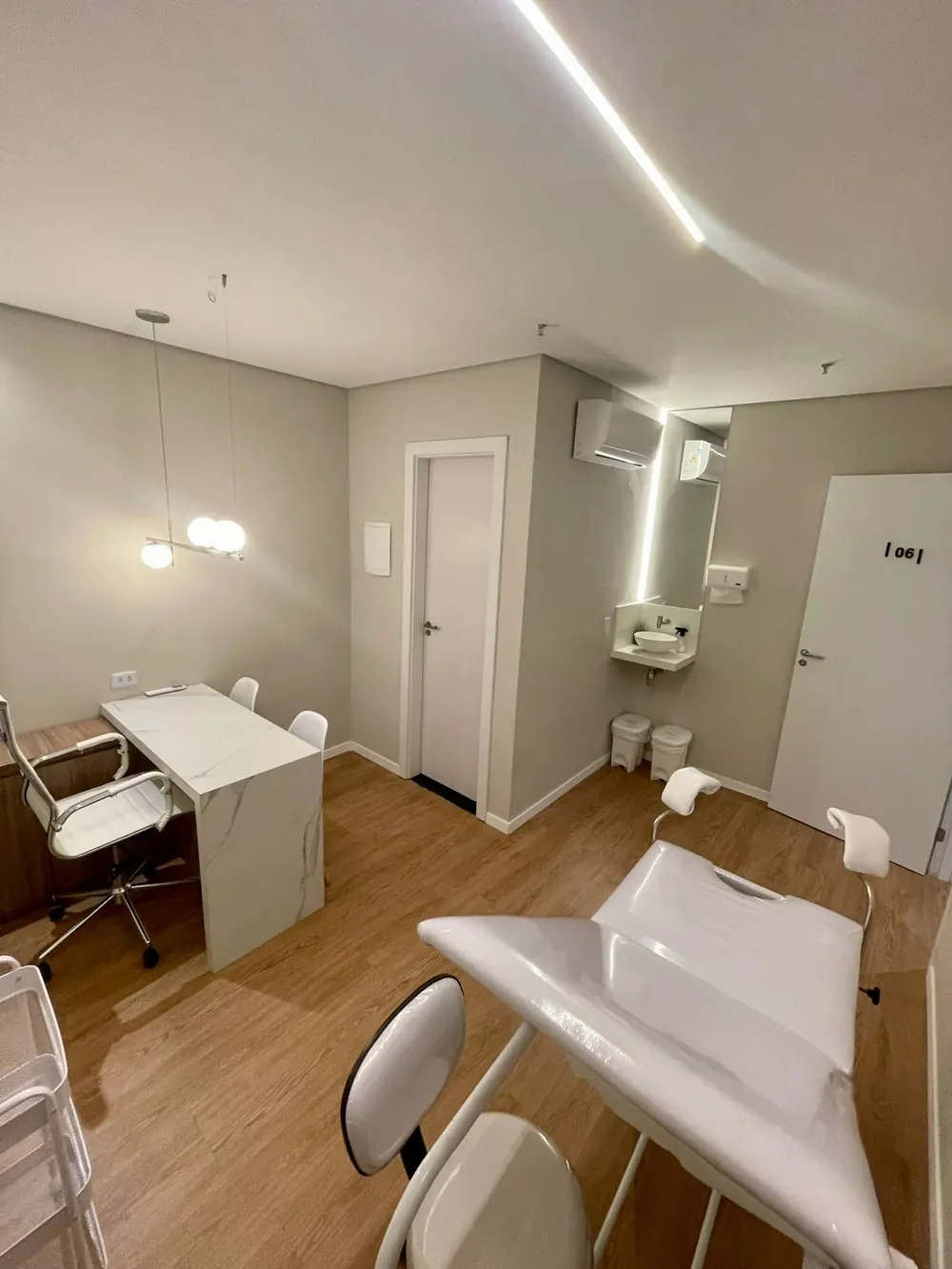 Consultório da Dra. Paula Lavigne no Umarizal, com mesa de atendimento e maca